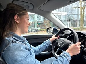 Geslaagde leerling achter het stuur van de lesauto